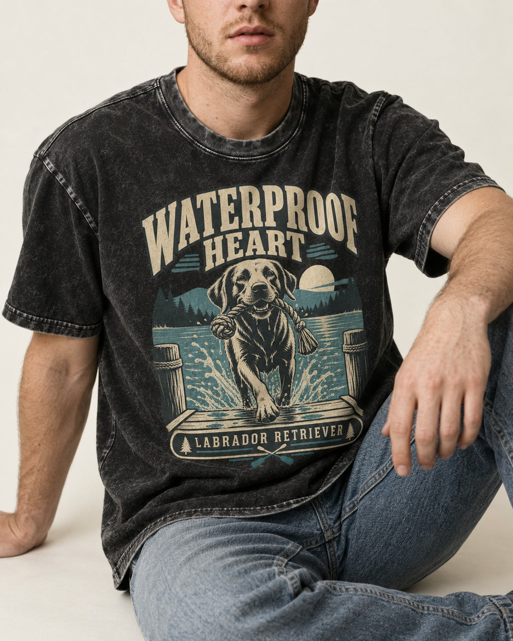 Labrador Retriever Waterproof Heart Lake Adventure Graphic Washed Tee in Black, worn by a seated model