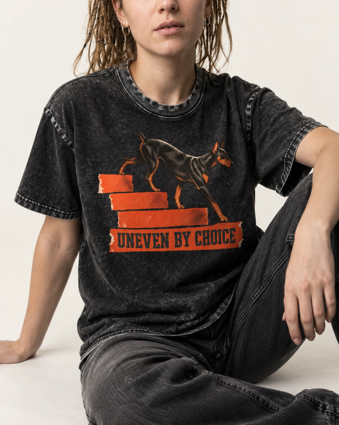 Doberman Uneven by Choice Stair Graphic Washed Tee in Black, worn by a seated model