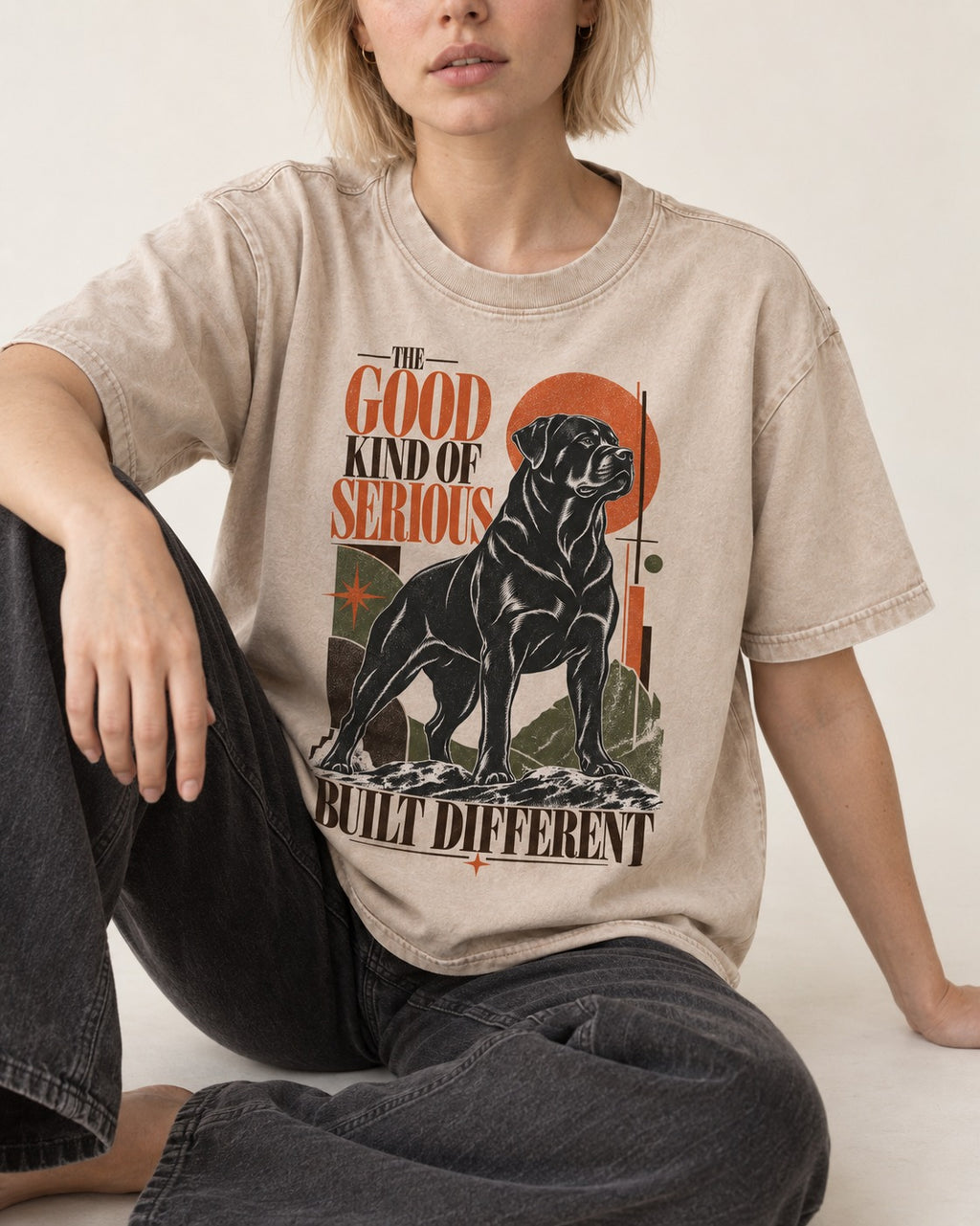Rottweiler Built Different Washed Tee in Apricot, worn by a seated model