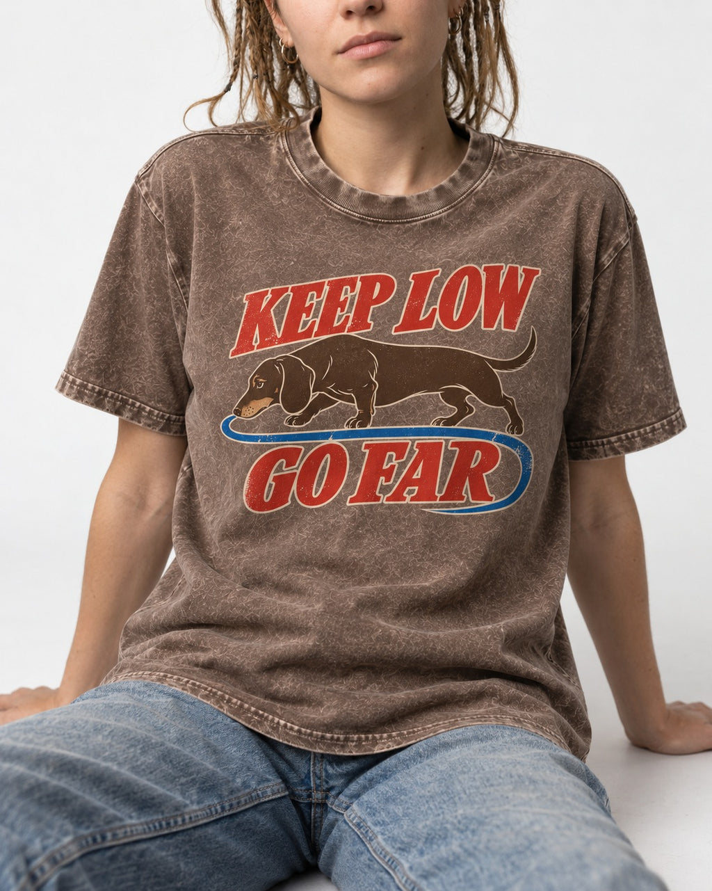 Dachshund Keep Low Go Far Washed Tee in Coffee, worn by a seated model