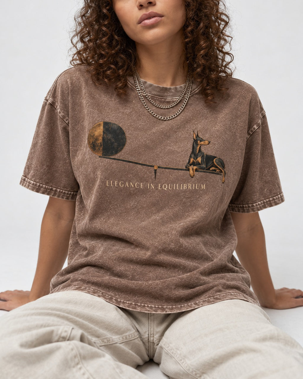 Doberman Elegance in Equilibrium Balance Graphic Washed Tee in Coffee, worn by a seated model