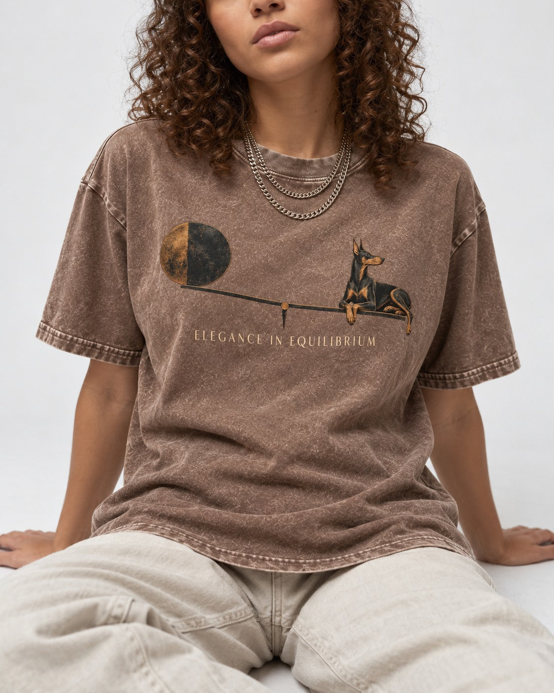 Doberman Elegance in Equilibrium Balance Graphic Washed Tee in Coffee, worn by a seated model
