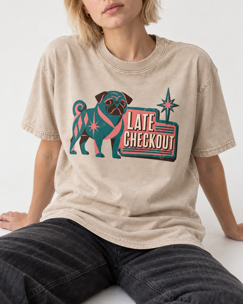 Pug's Late Checkout Washed Tee in Apricot, worn by a seated model