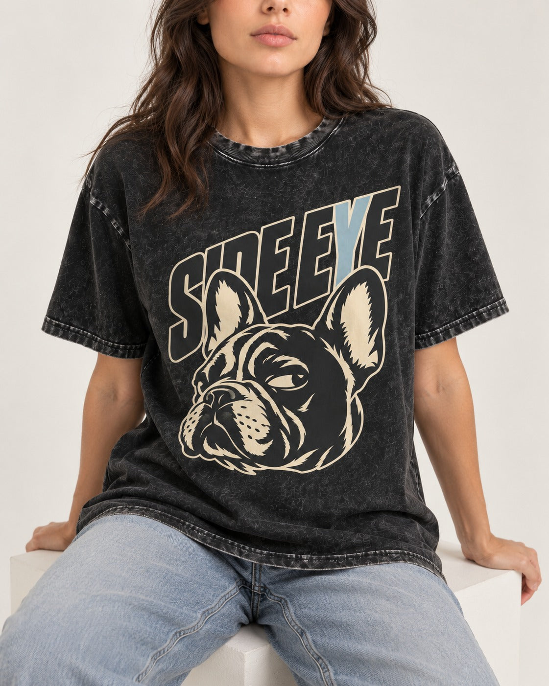 Frenchie Side Eye Portrait Graphic Washed Tee in Black, worn by a seated model