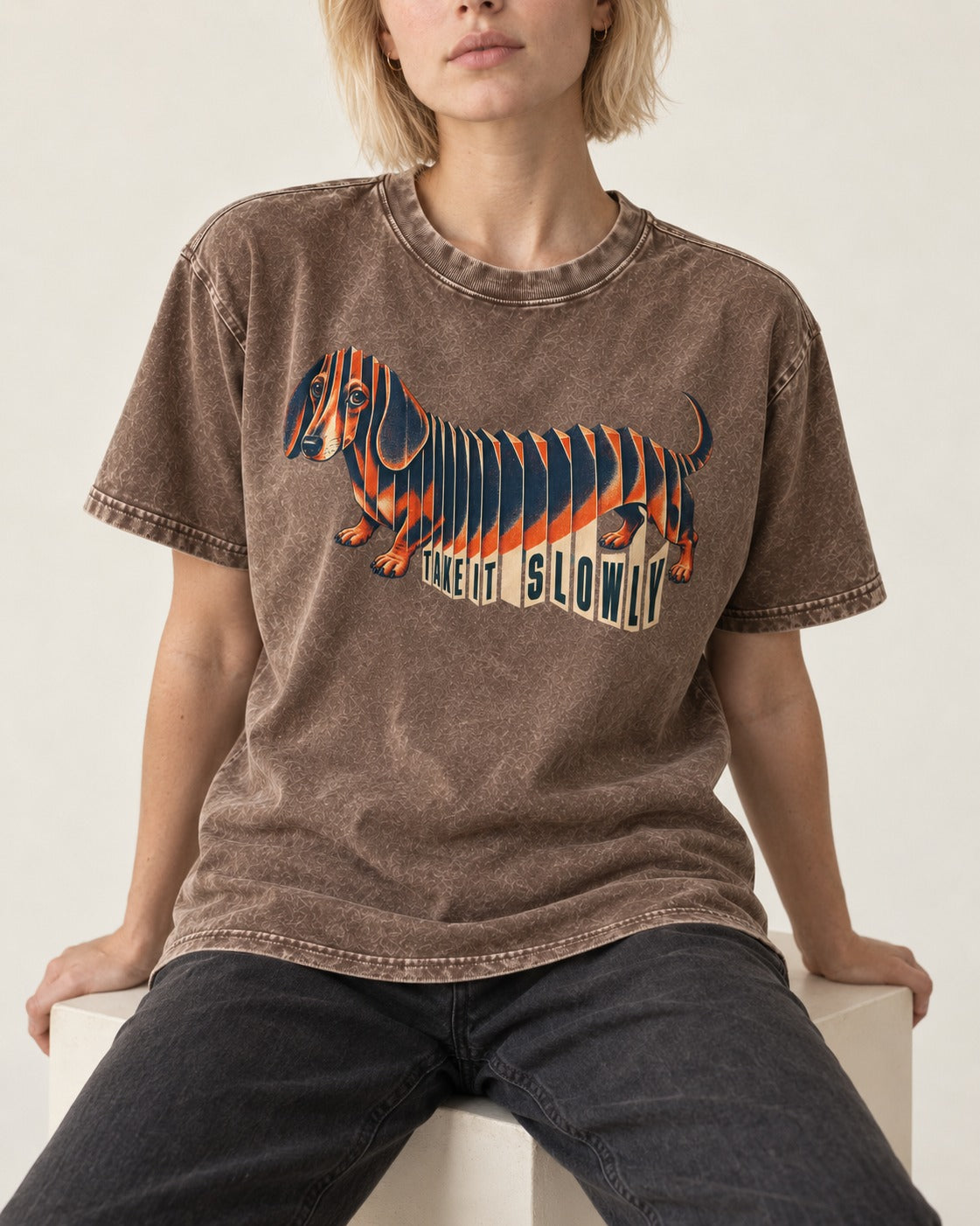 Take It Slowly Dachshund Washed Tee in Coffee, worn by a seated model