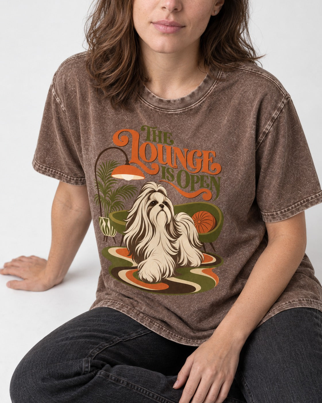 The Shih Tzu Lounge Is Open Washed Tee in Coffee, worn by a seated model
