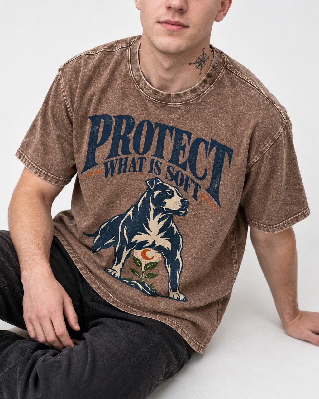 Protect What Is Soft Pitbull Washed Tee in Coffee, worn by a seated model