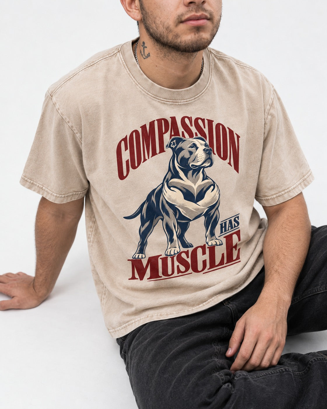 Pitbull Compassion Has Muscle Washed Tee in Apricot, worn by a seated model