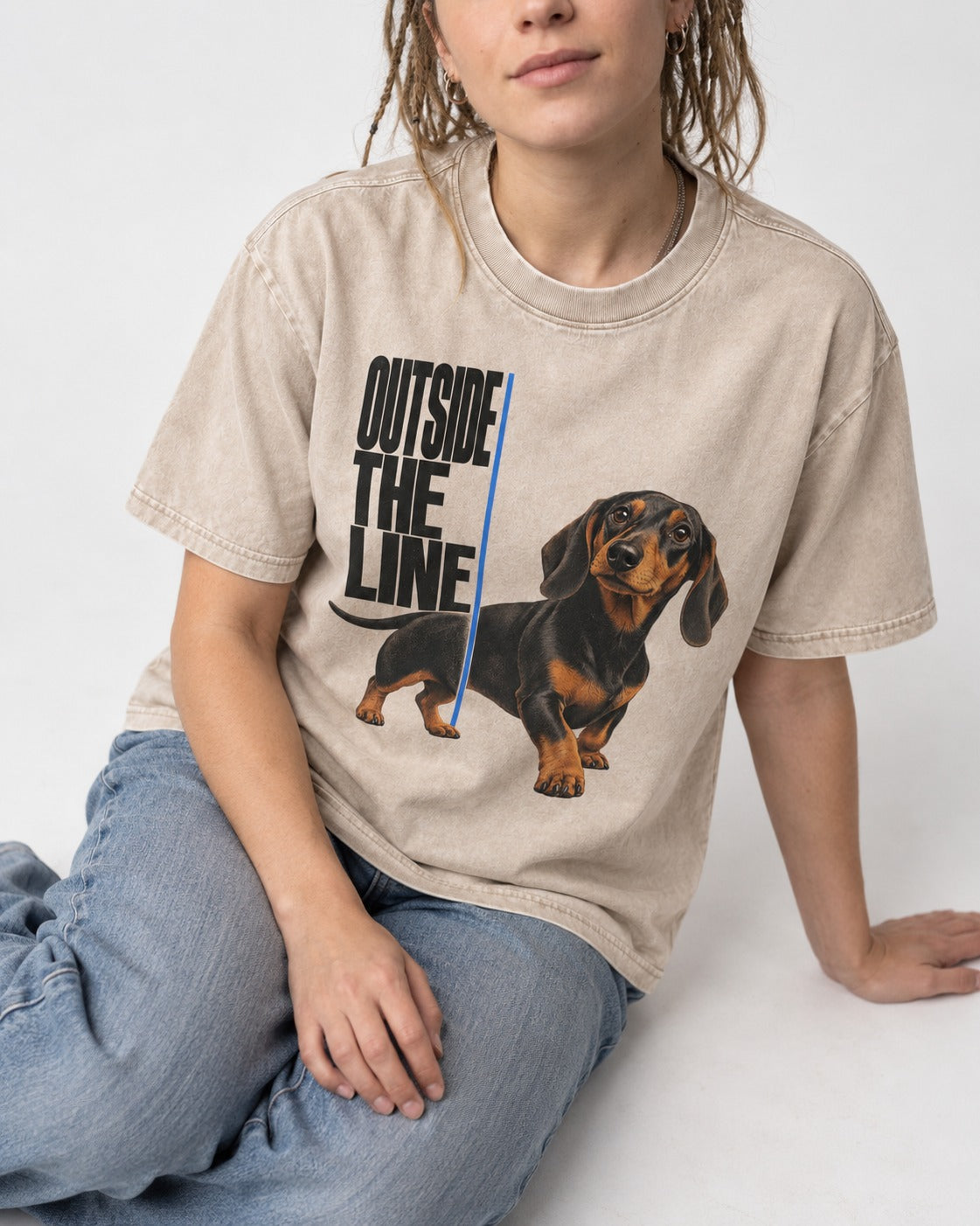 Dachshund Outside the Line Washed Tee in Apricot, worn by a seated model