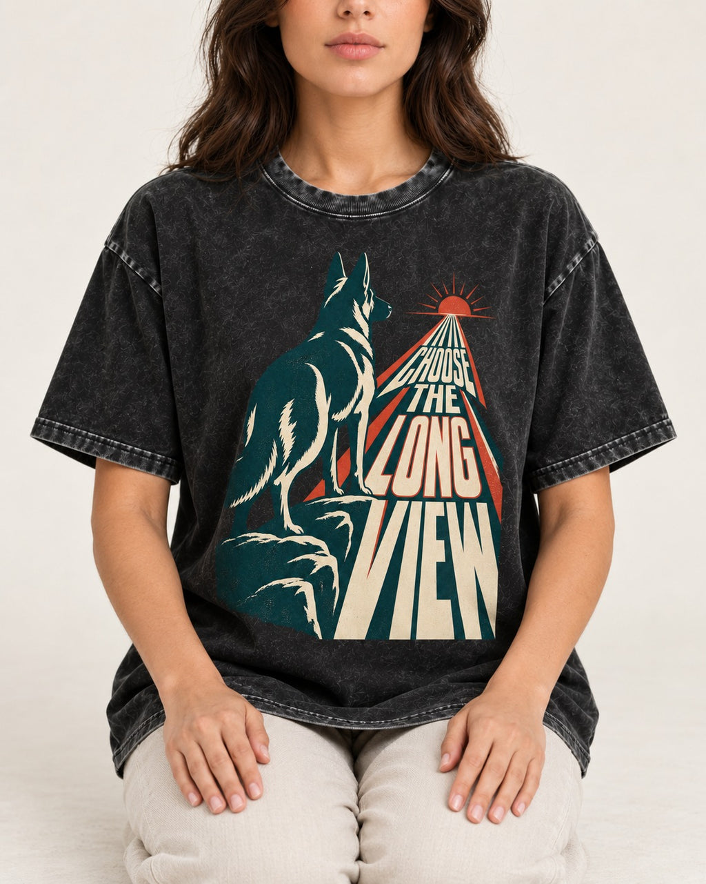 Choose the Long View Sunrise German Shepherd Dog Graphic Washed Tee in Black, worn by a seated model