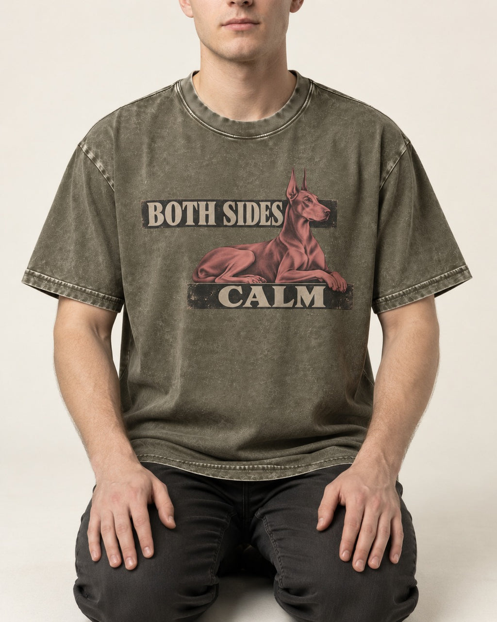 Doberman Both Sides Calm Banner Washed Tee in Army Green, worn by a seated model