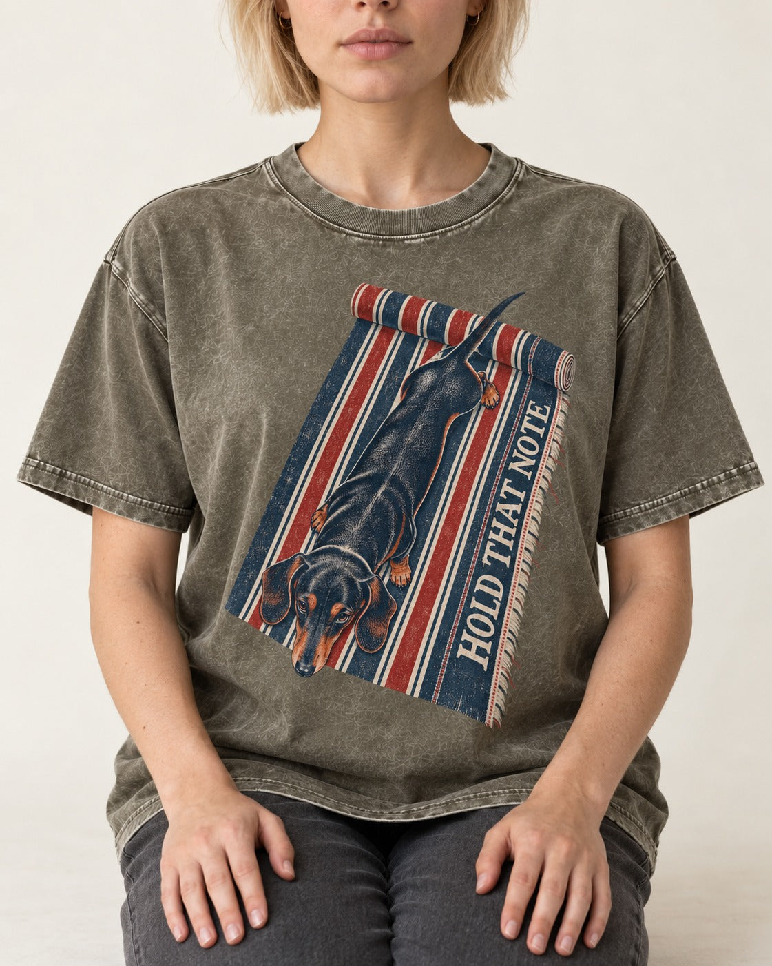 Dachshund Hold That Note Striped Rug Graphic Washed Tee in Army Green, worn by a seated model