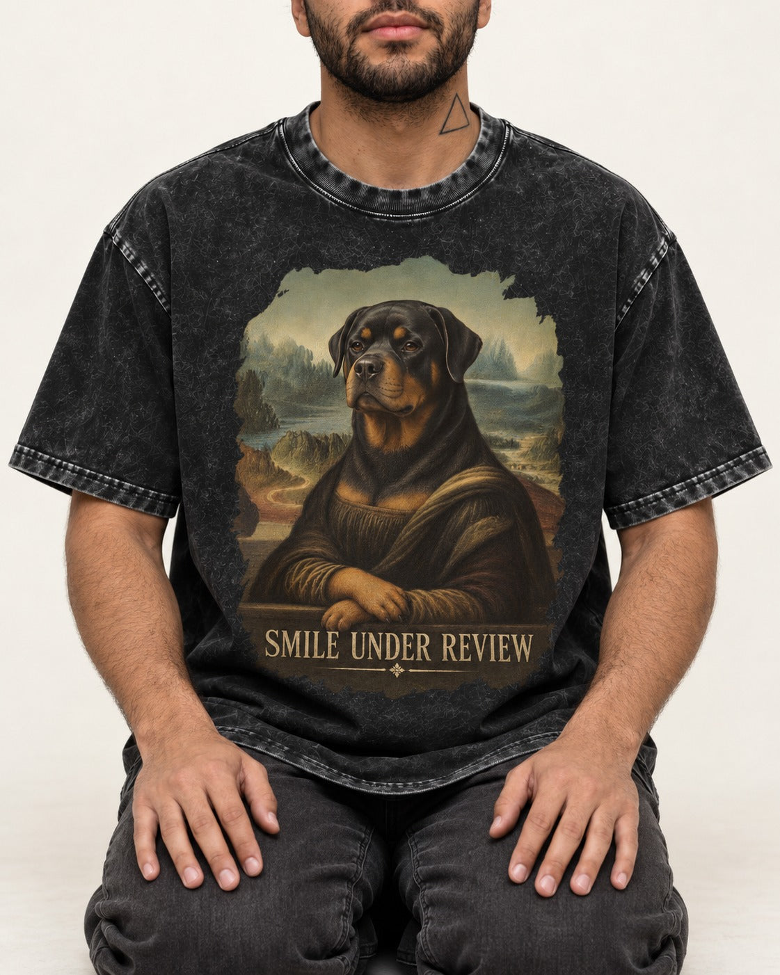 Rottweiler Smile Under Review Renaissance Portrait Graphic Washed Tee in Black, worn by a seated model