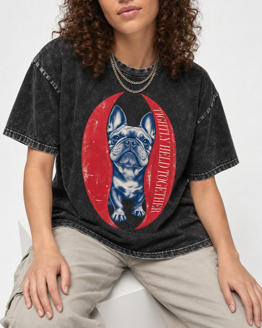 Frenchie Tightly Held Together Red Oval Graphic Washed Tee in Black, worn by a seated model