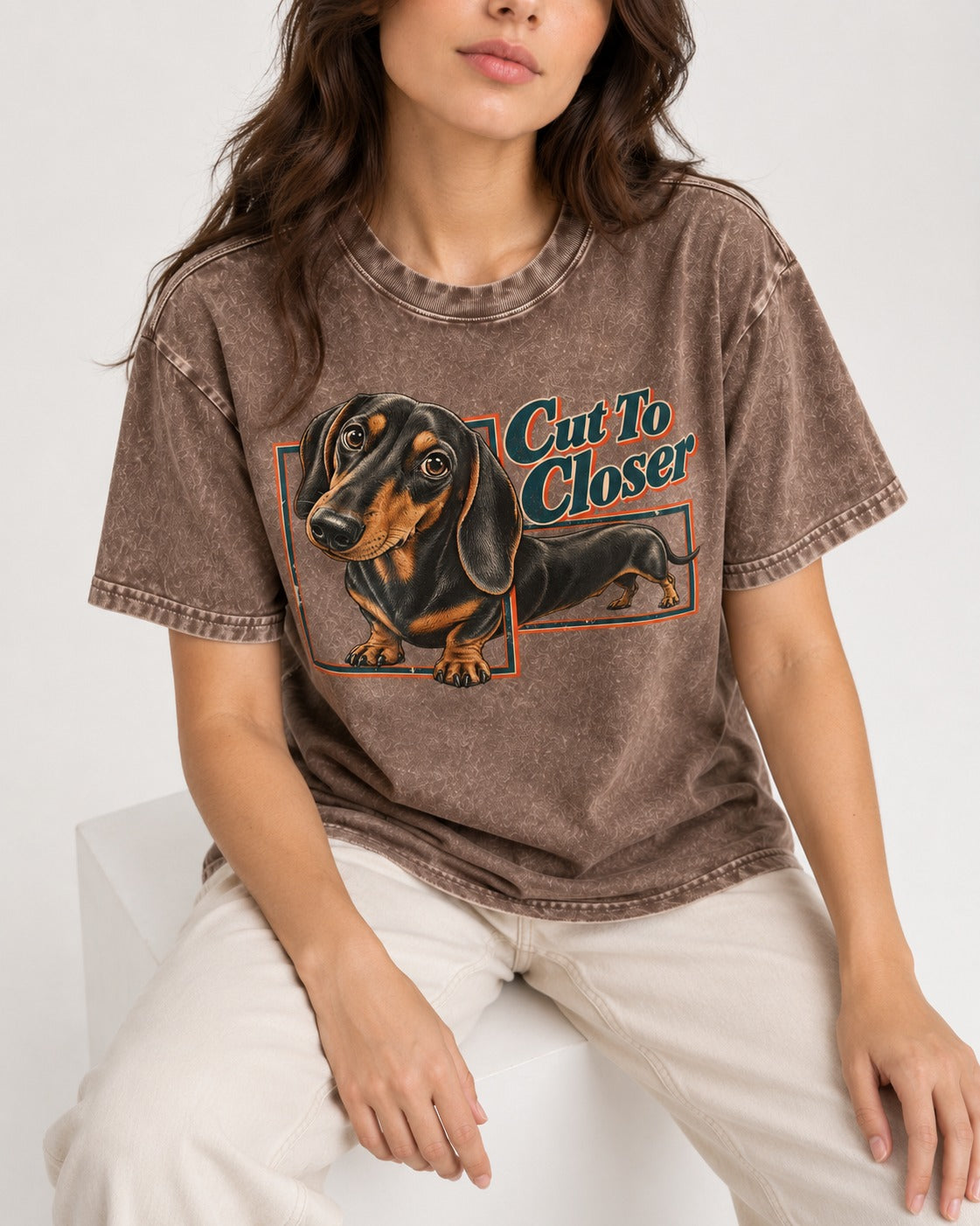 Dachshund Cut to Closer Washed Tee in Coffee, worn by a seated model