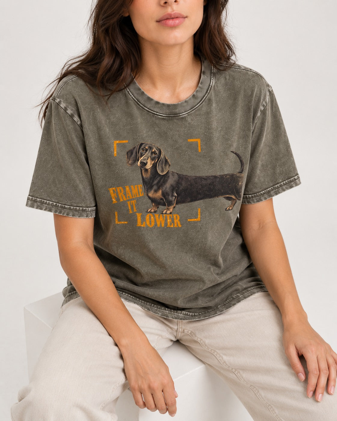 Dachshund Frame It Lower Viewfinder Graphic Washed Tee in Army Green, worn by a seated model