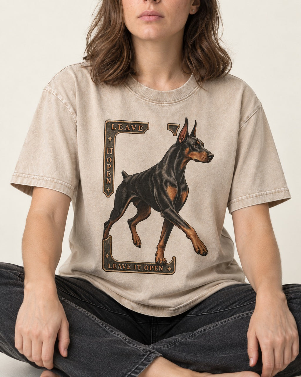 Leave It Open Doberman Washed Tee in Apricot, worn by a seated model