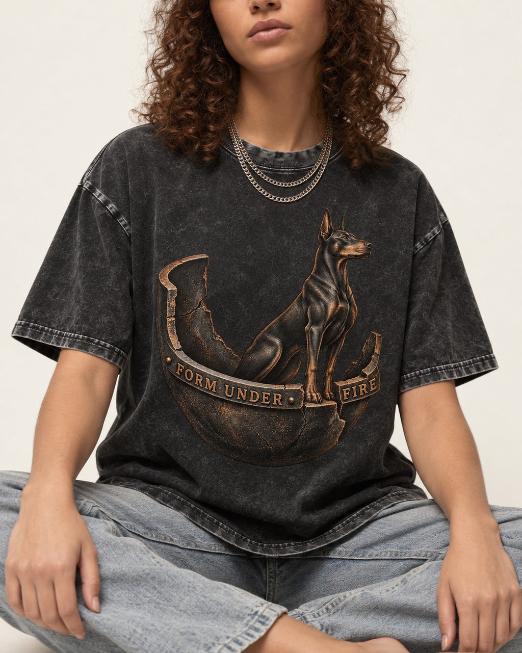 Doberman Form Under Fire Broken Shell Graphic Washed Tee in Black, worn by a seated model