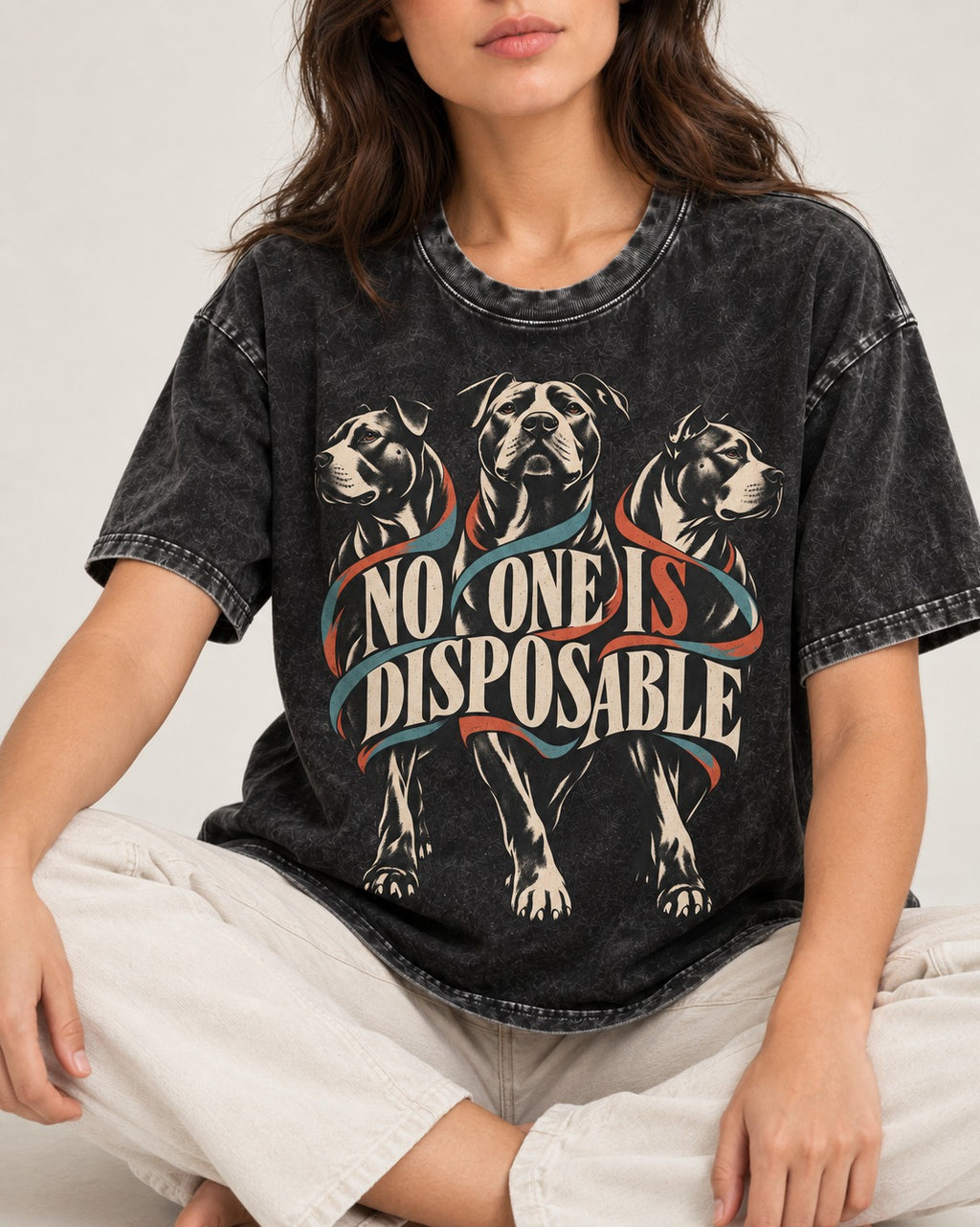 Pitbull No One Is Disposable Three Dogs Graphic Washed Tee in Black, worn by a seated model
