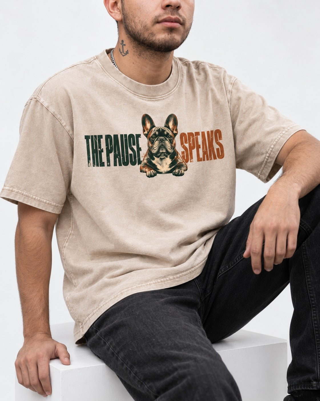 The Frenchie Pause Speaks Washed Tee in Apricot, worn by a seated model