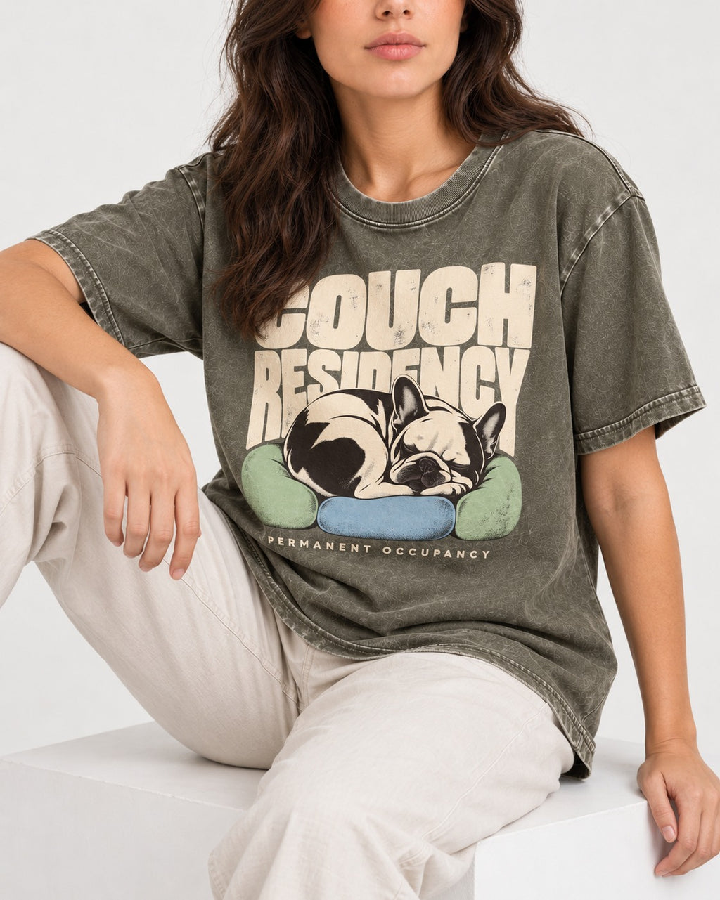 Frenchie Couch Residency Permanent Occupancy Cushion Graphic Washed Tee in Army Green, worn by a seated model