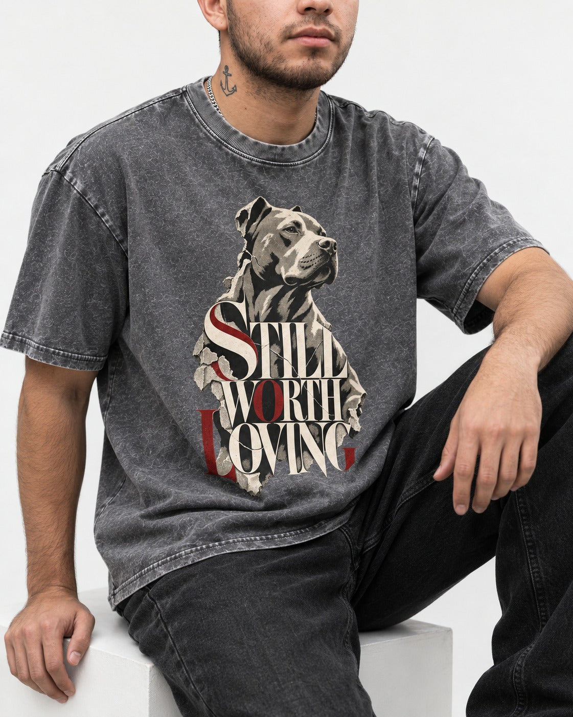 Pitbull Still Worth Loving Torn Poster Portrait Graphic Washed Tee in Gray, worn by a seated model