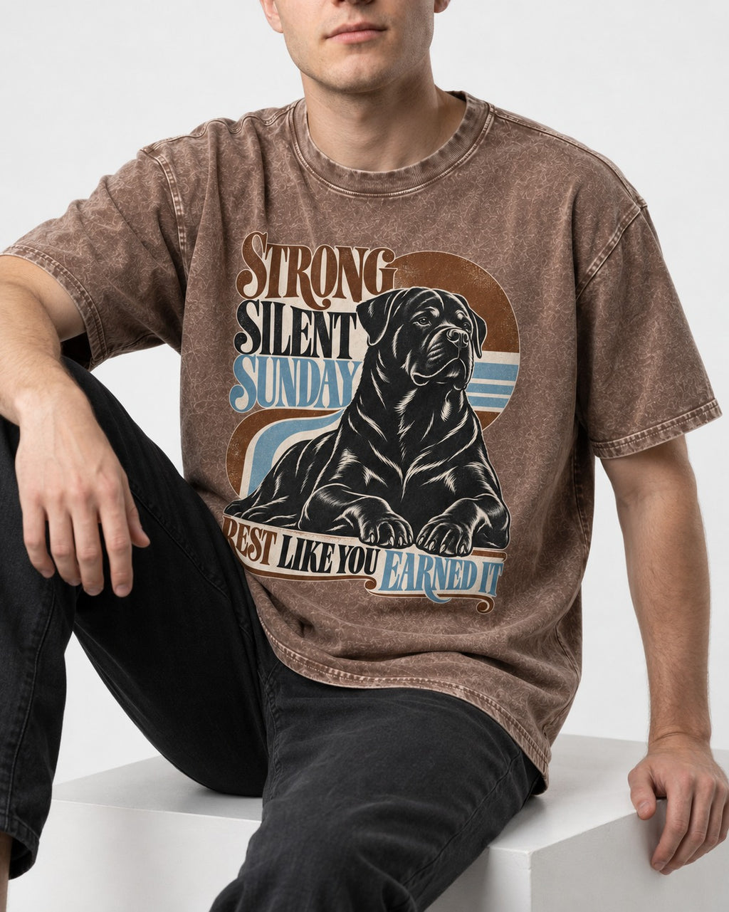 Strong Silent Sunday Rottweiler Washed Tee in Coffee, worn by a seated model