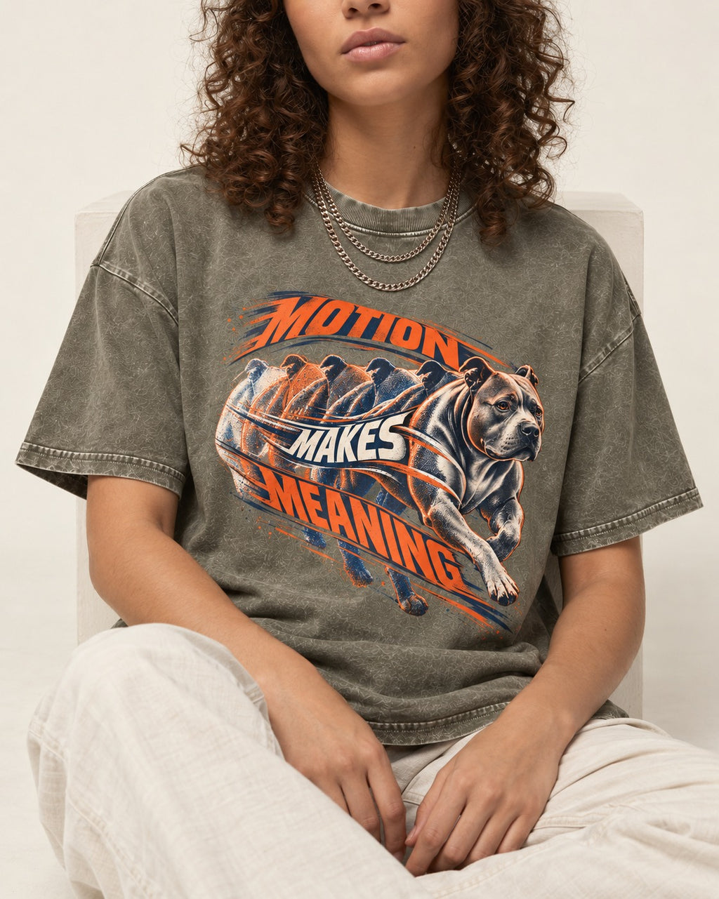 Pitbull Motion Makes Meaning Running Dog Graphic Washed Tee in Army Green, worn by a seated model