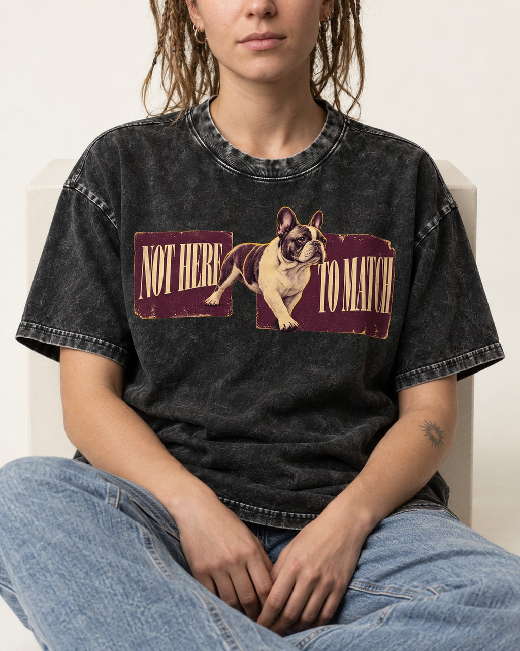 Frenchie Not Here to Watch Panels Graphic Washed Tee in Black, worn by a seated model
