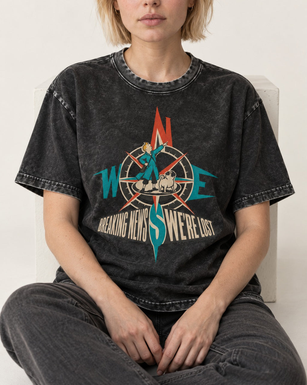 Pug Breaking News We're Lost Compass Graphic Washed Tee in Black, worn by a seated model