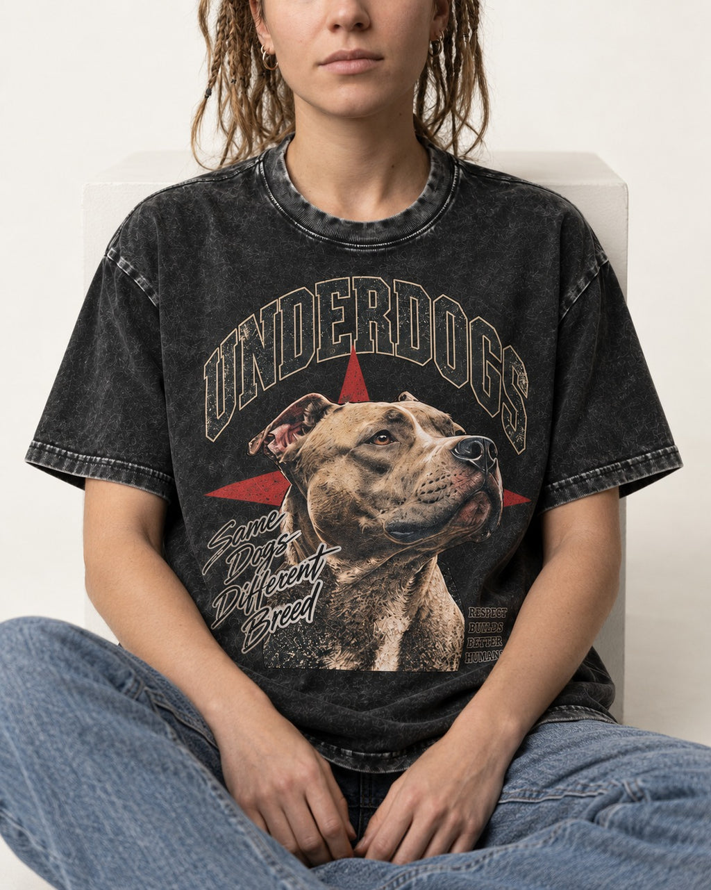 Pitbull Underdogs Same Dogs Different Breed Portrait Graphic Washed Tee in Black, worn by a seated model