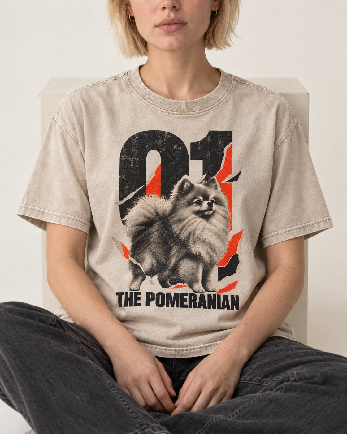 The Pomeranian Washed Tee in Apricot, worn by a seated model