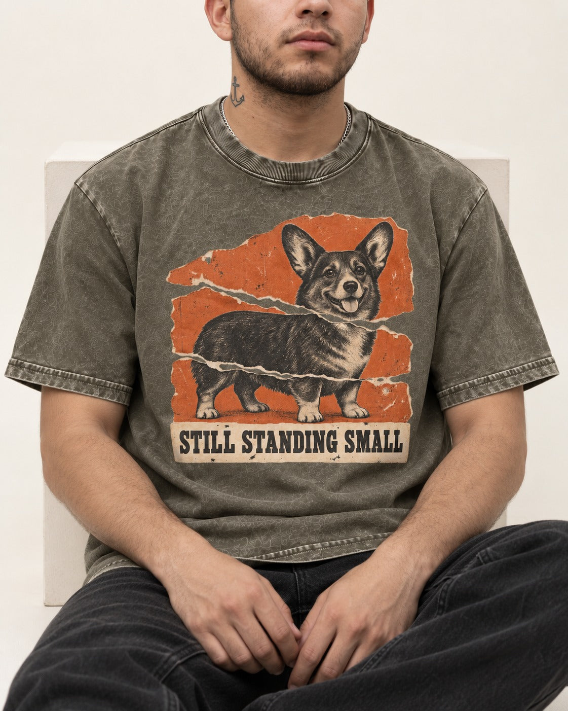 Corgi Still Standing Small Torn Poster Washed Tee in Army Green, worn by a seated model