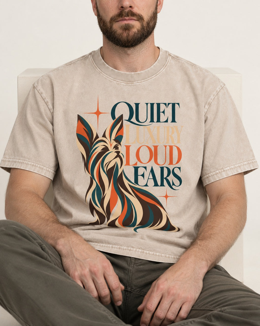 Quiet Luxury Loud Ears Yorkshire Terrier Washed Tee in Apricot, worn by a seated model