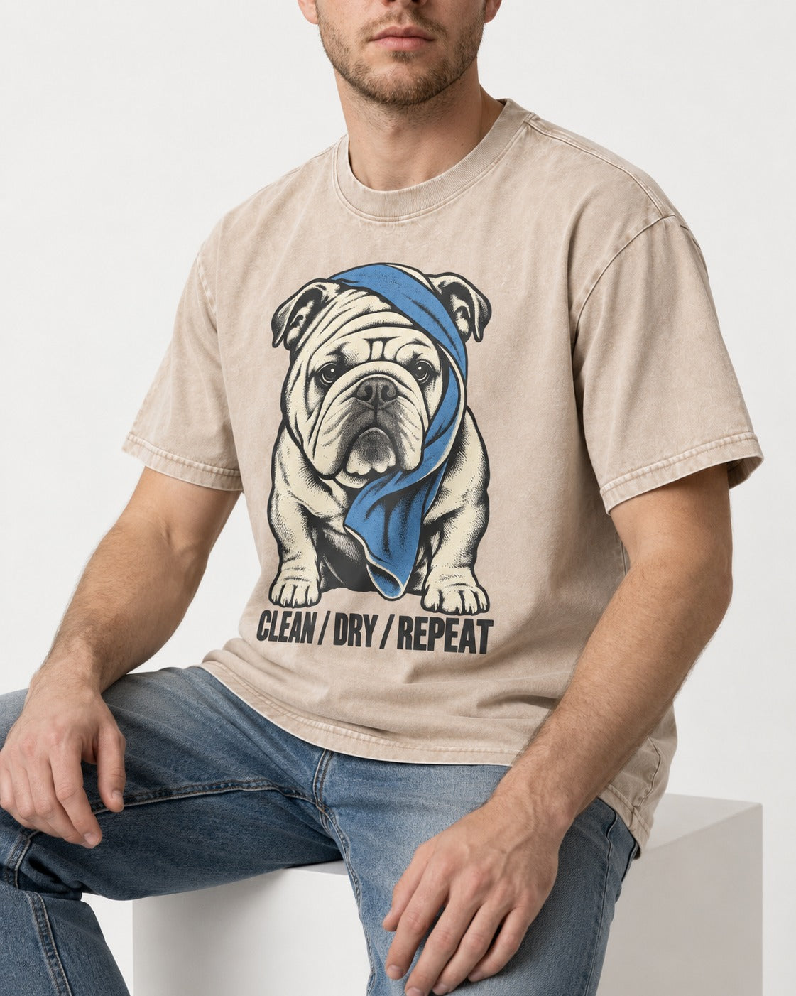 Clean Dry Repeat English Bulldog Washed Tee in Apricot, worn by a seated model