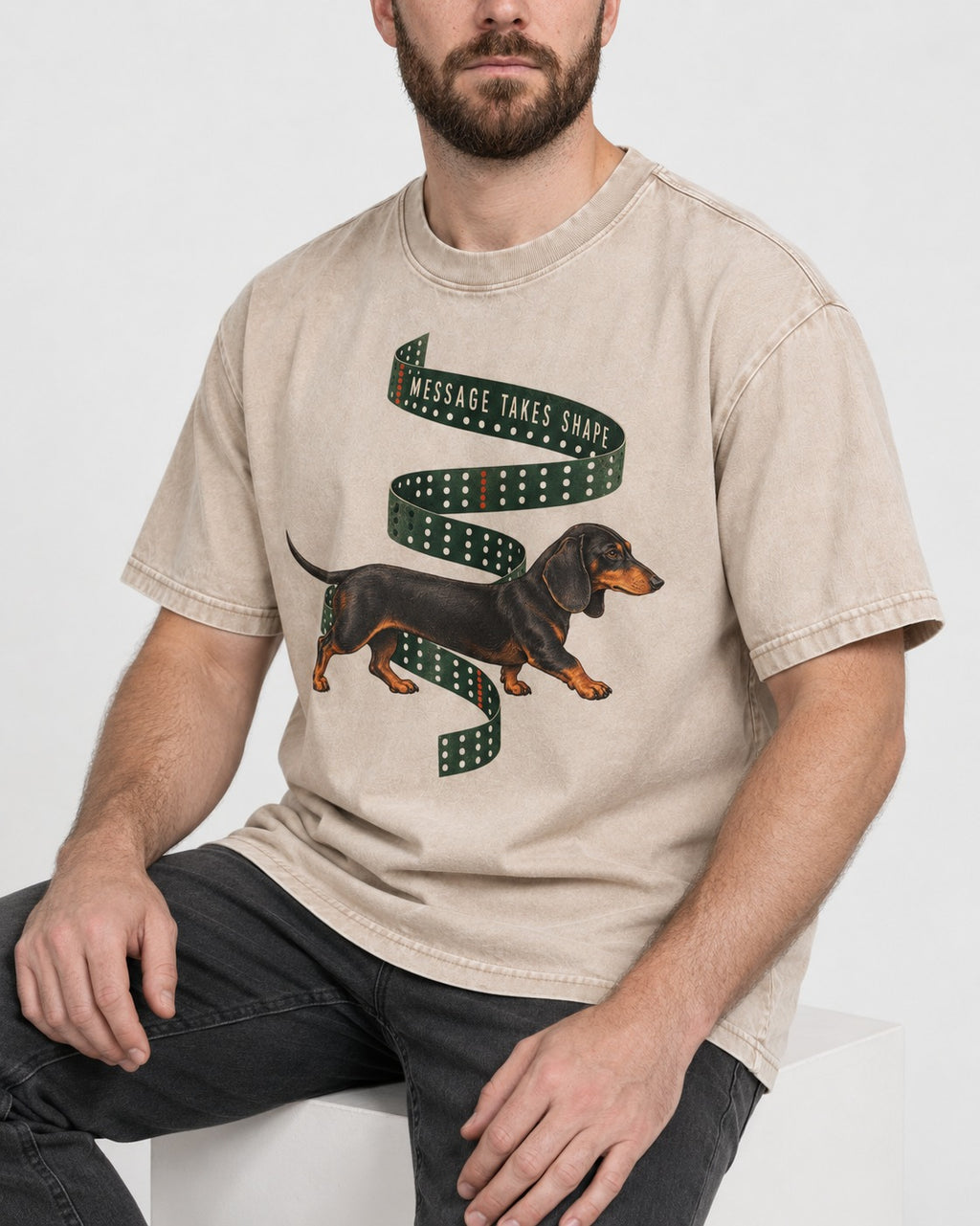 Dachshund Message Takes Shape Washed Tee in Apricot, worn by a seated model