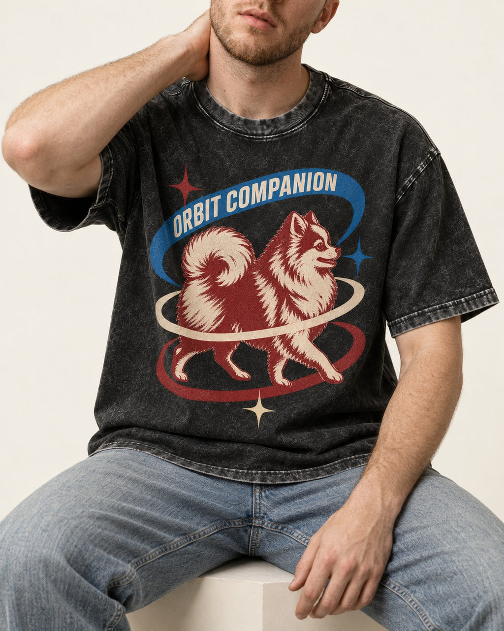 Pomeranian Orbit Companion Retro Space Graphic Washed Tee in Black, worn by a seated model