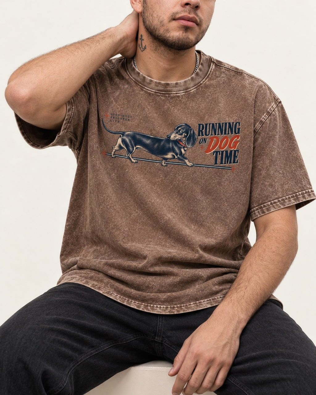 Dachshund Lengthens Life Washed Tee in Coffee, worn by a seated model