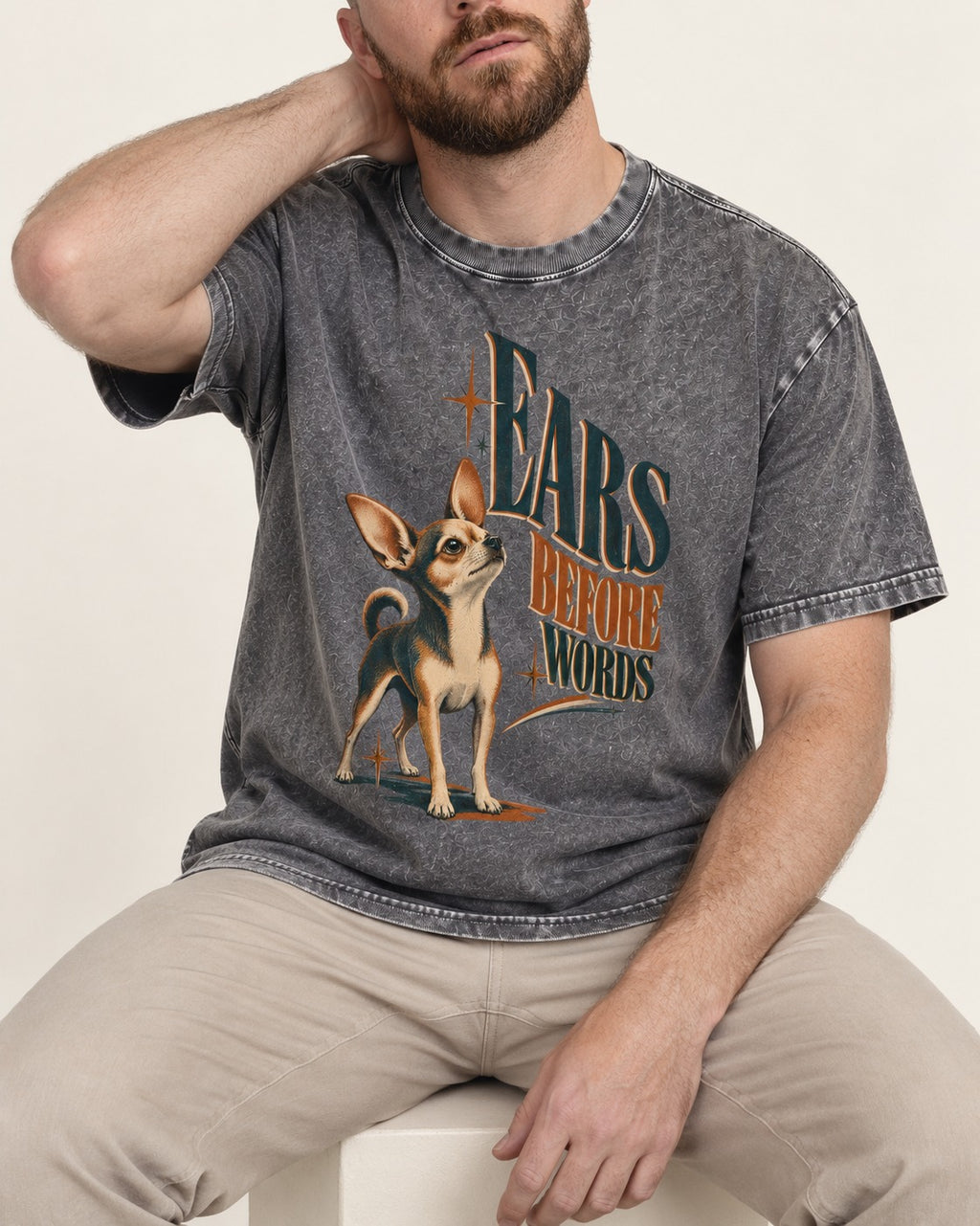 Chihuahua Ears Before Words Retro Typography Washed Tee in Gray, worn by a seated model