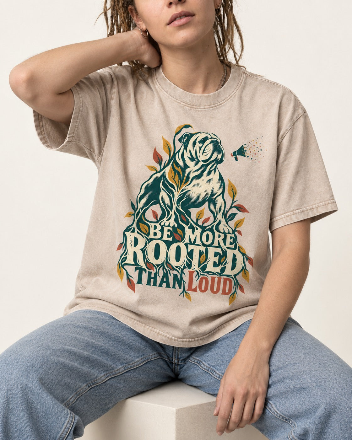 More Rooted Than Loud English Bulldog Washed Tee in Apricot, worn by a seated model