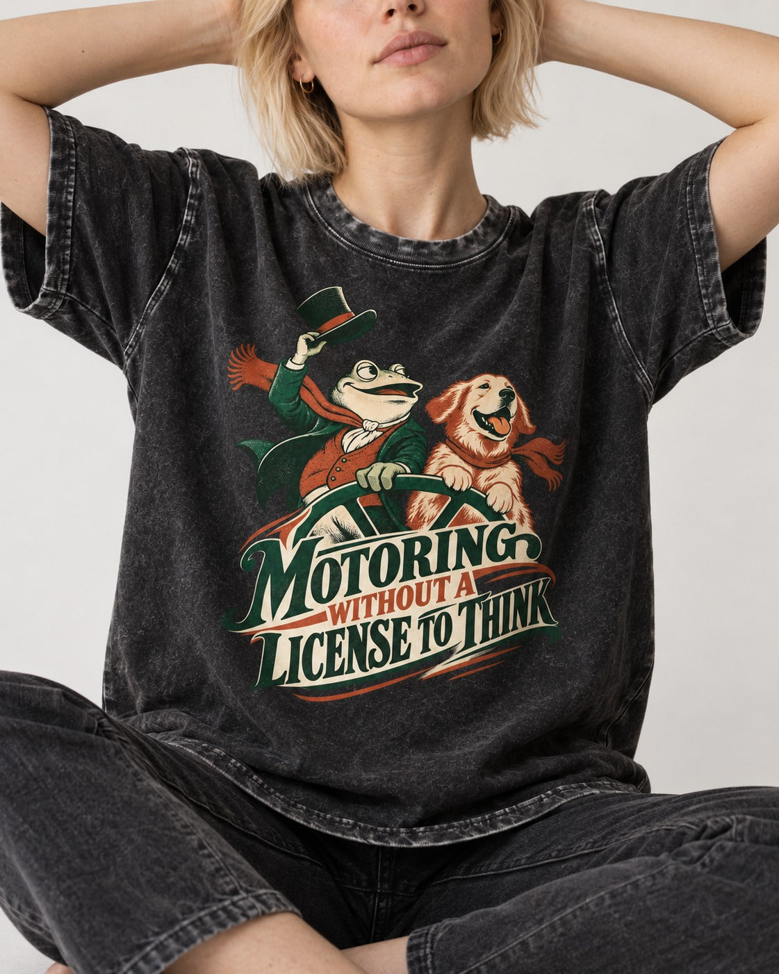 Golden Retriever Motoring Without a License to Think Driving Graphic Washed Tee in Black, worn by a seated model
