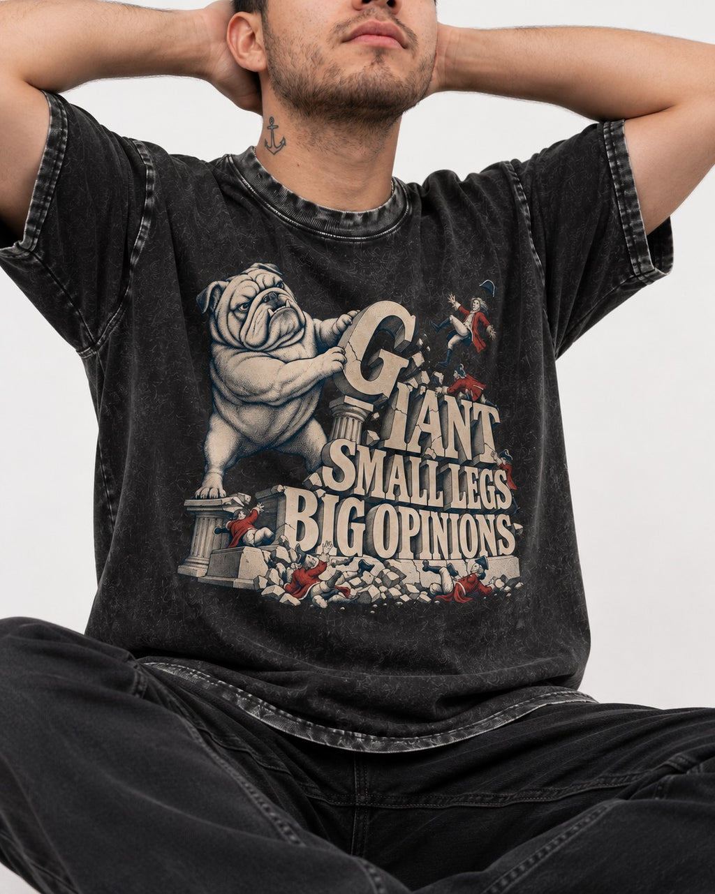 English Bulldog Giant Small Legs Big Opinions Monument Graphic Washed Tee in Black, worn by a seated model
