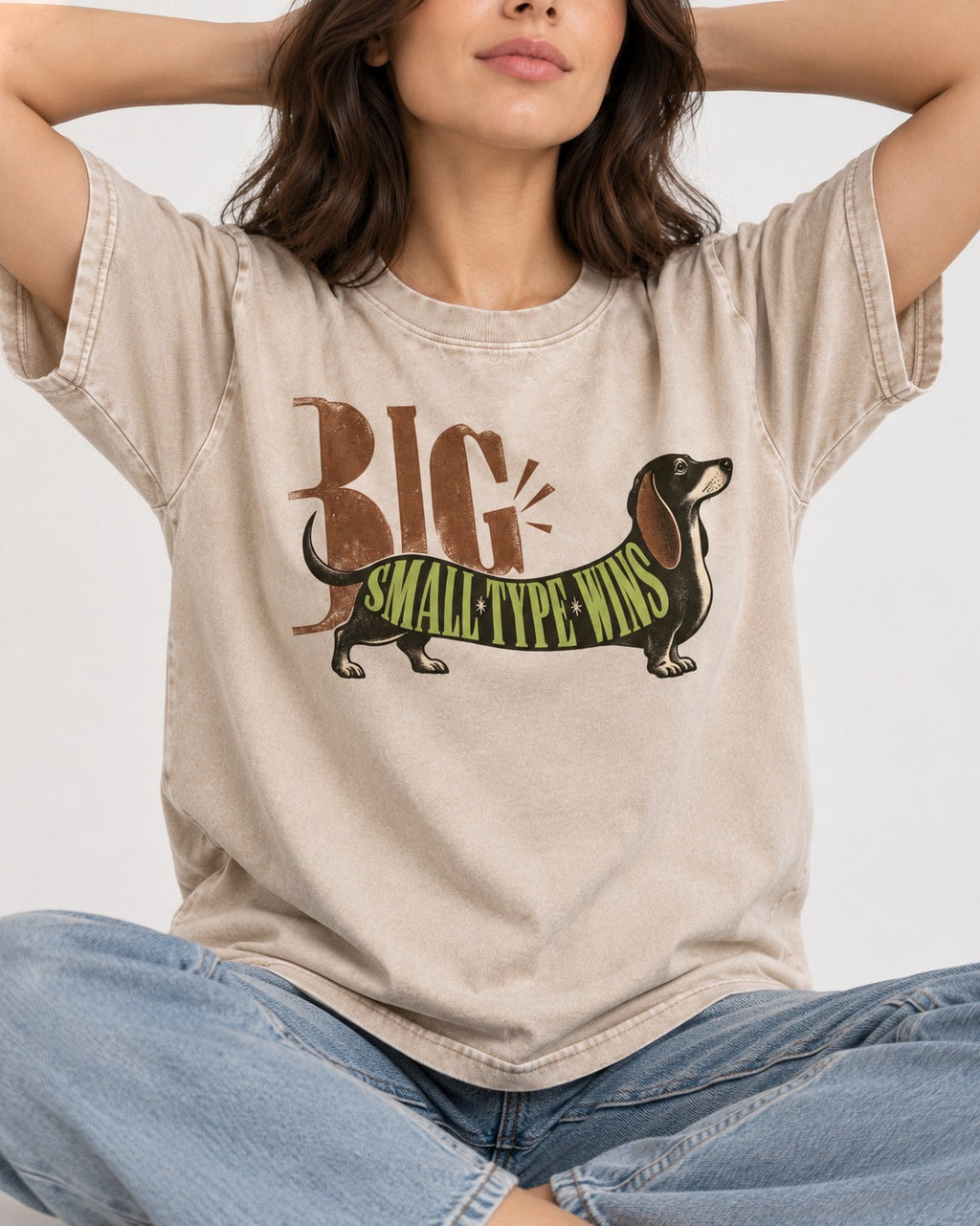 Dachshund Small Type Wins Washed Tee in Apricot, worn by a seated model