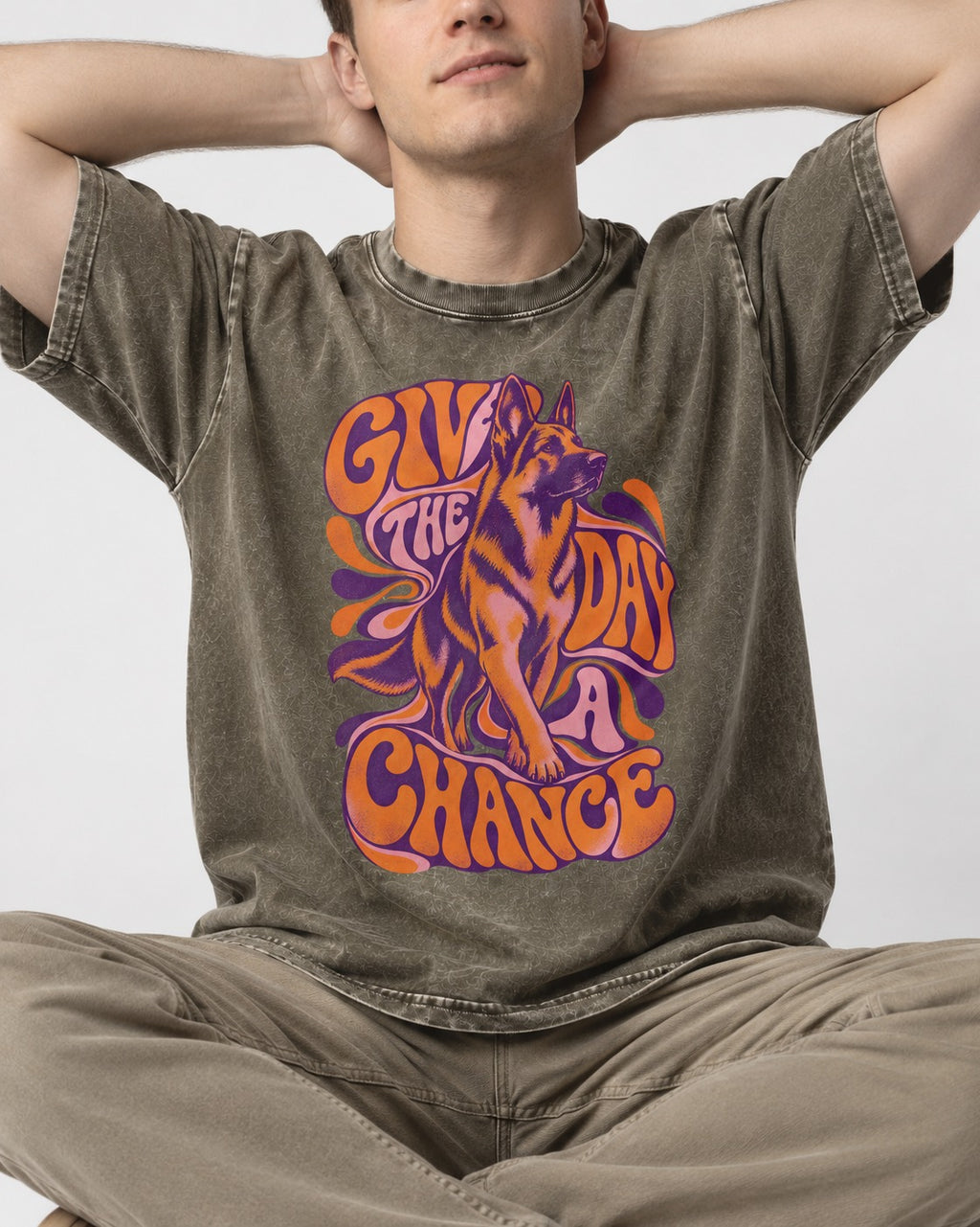 Give The Day A Chance Psychedelic German Shepherd Dog Graphic Washed Tee in Army Green, worn by a seated model