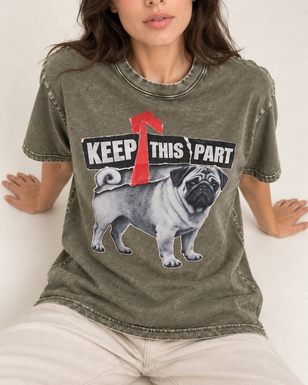 Pug Keep This Part Tape Arrow Graphic Washed Tee in Army Green, worn by a seated model