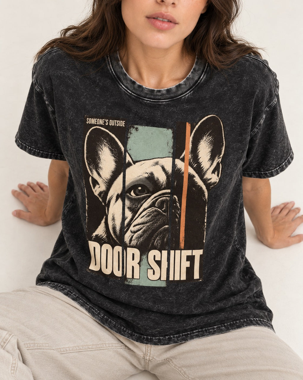 Frenchie Someone's Outside Door Shift Graphic Washed Tee in Black, worn by a seated model