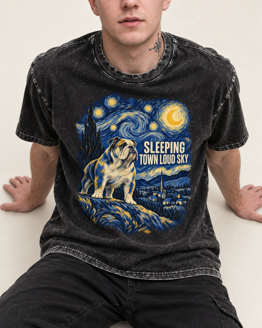 English Bulldog Sleeping Town Loud Sky Starry Night Graphic Washed Tee in Black, worn by a seated model