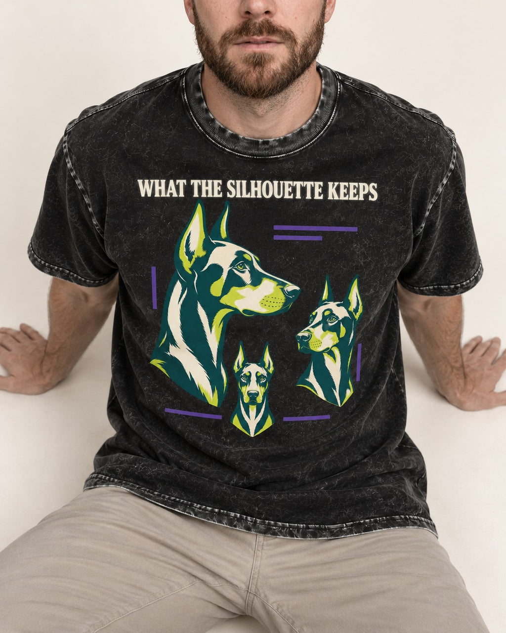 Doberman What the Silhouette Keeps Three Portrait Graphic Washed Tee in Black, worn by a seated model