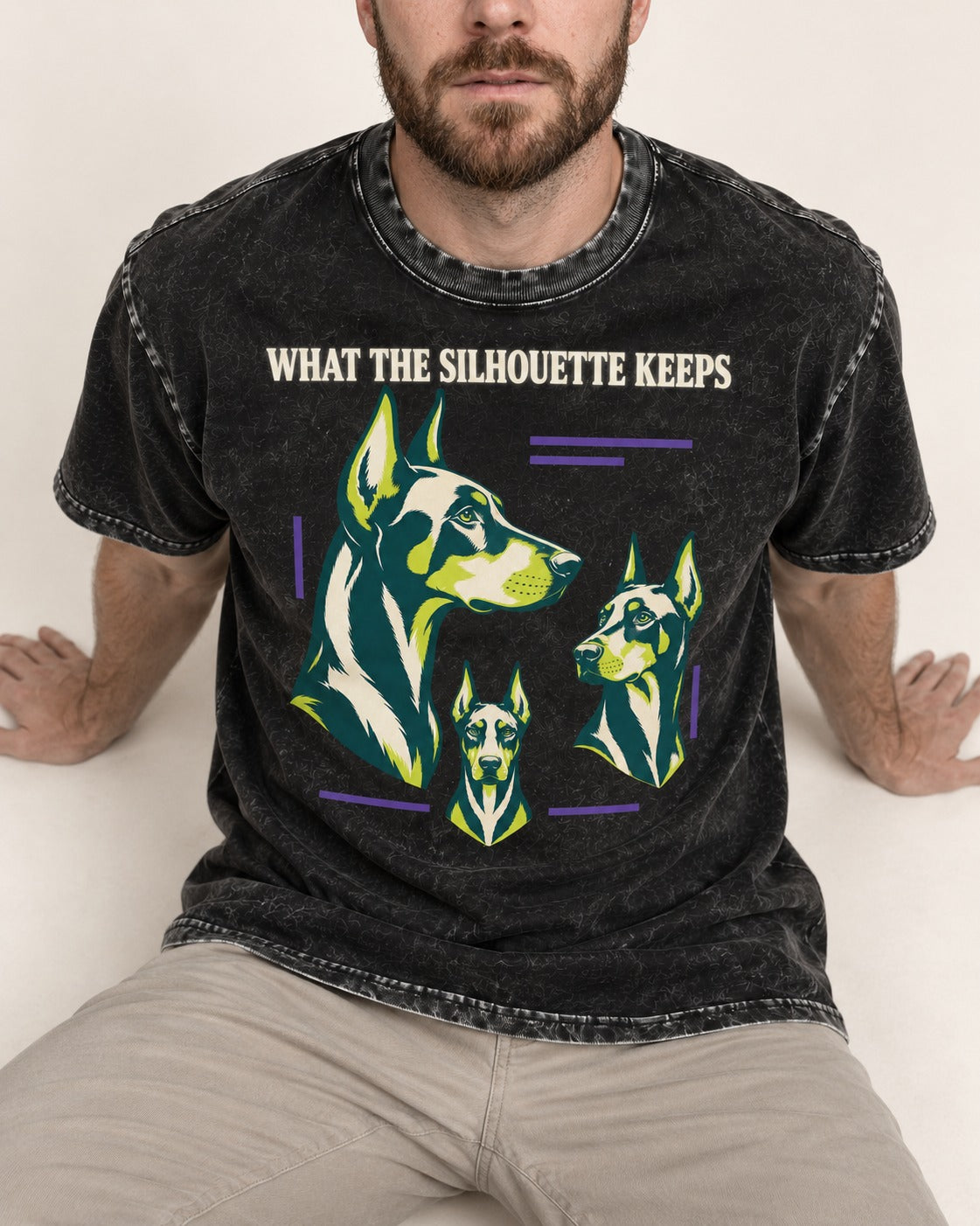 Doberman What the Silhouette Keeps Three Portrait Graphic Washed Tee in Black, worn by a seated model