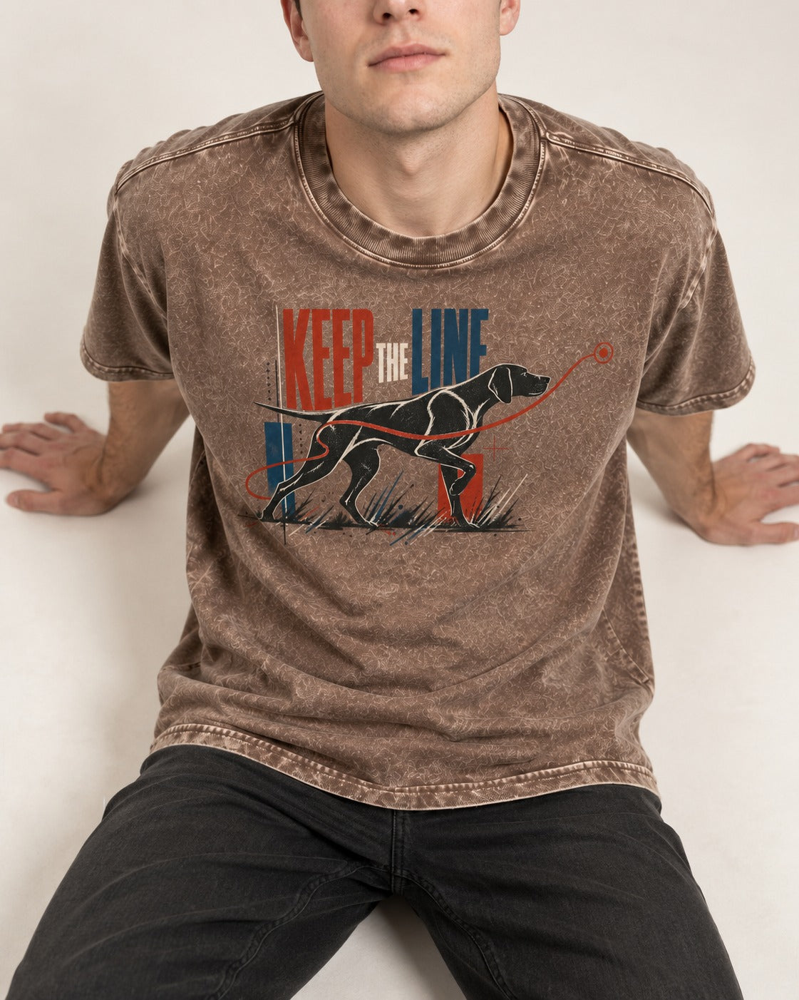 Keep the Line German Shorthaired Pointer Washed Tee in Coffee, worn by a seated model